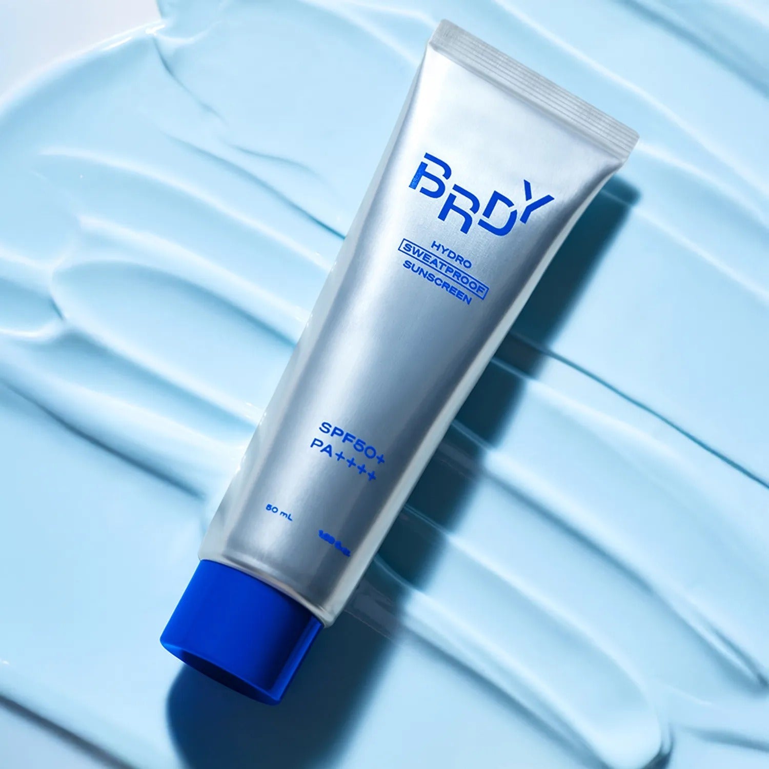 B.READY Hydro Sweatproof Sunscreen 50ml - Gentleman Korea product shot of silver tube on blue cream background, SPF50+ sweatproof sunscreen for men